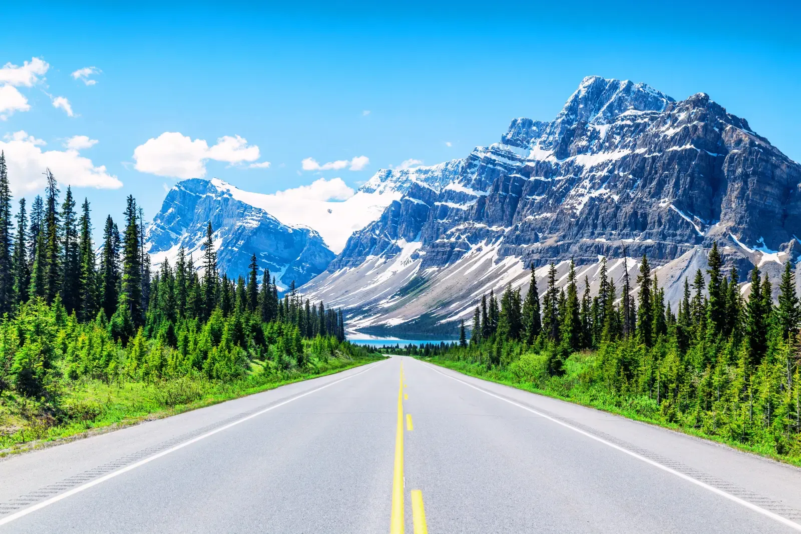 A mountain highway climbing through the Canadian Rockies at sunrise
